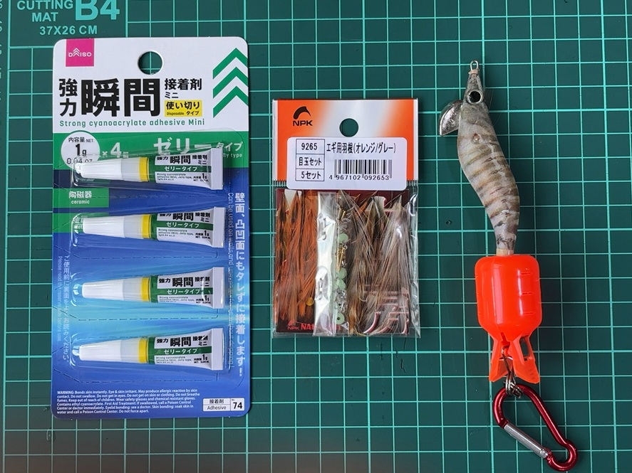 エギの羽根修理に必要な材料。羽根の取れたエギ、瞬間接着剤、修理用の羽根を並べた写真
